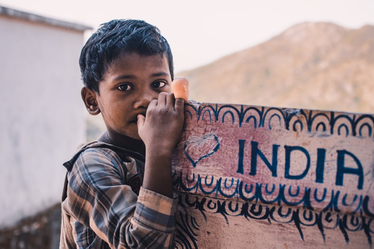 Close-Up Photography Of A Boy Near A Signboard